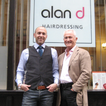 Alan d founder Alan Hemmings & director Edward Hemmings in front of the alan d logo.