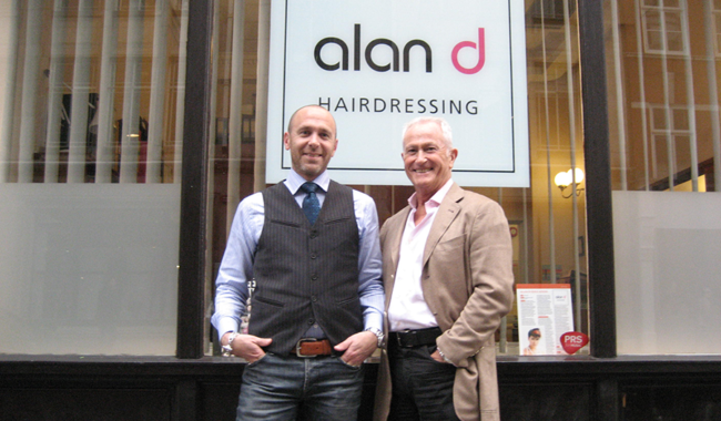 Alan d founder Alan Hemmings & director Edward Hemmings in front of the alan d logo.