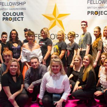 Alan d students and staff in front of fellowship backdrop at Salon International.