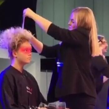 Alan d student styling a womans hair at the Salon International Exhibition.
